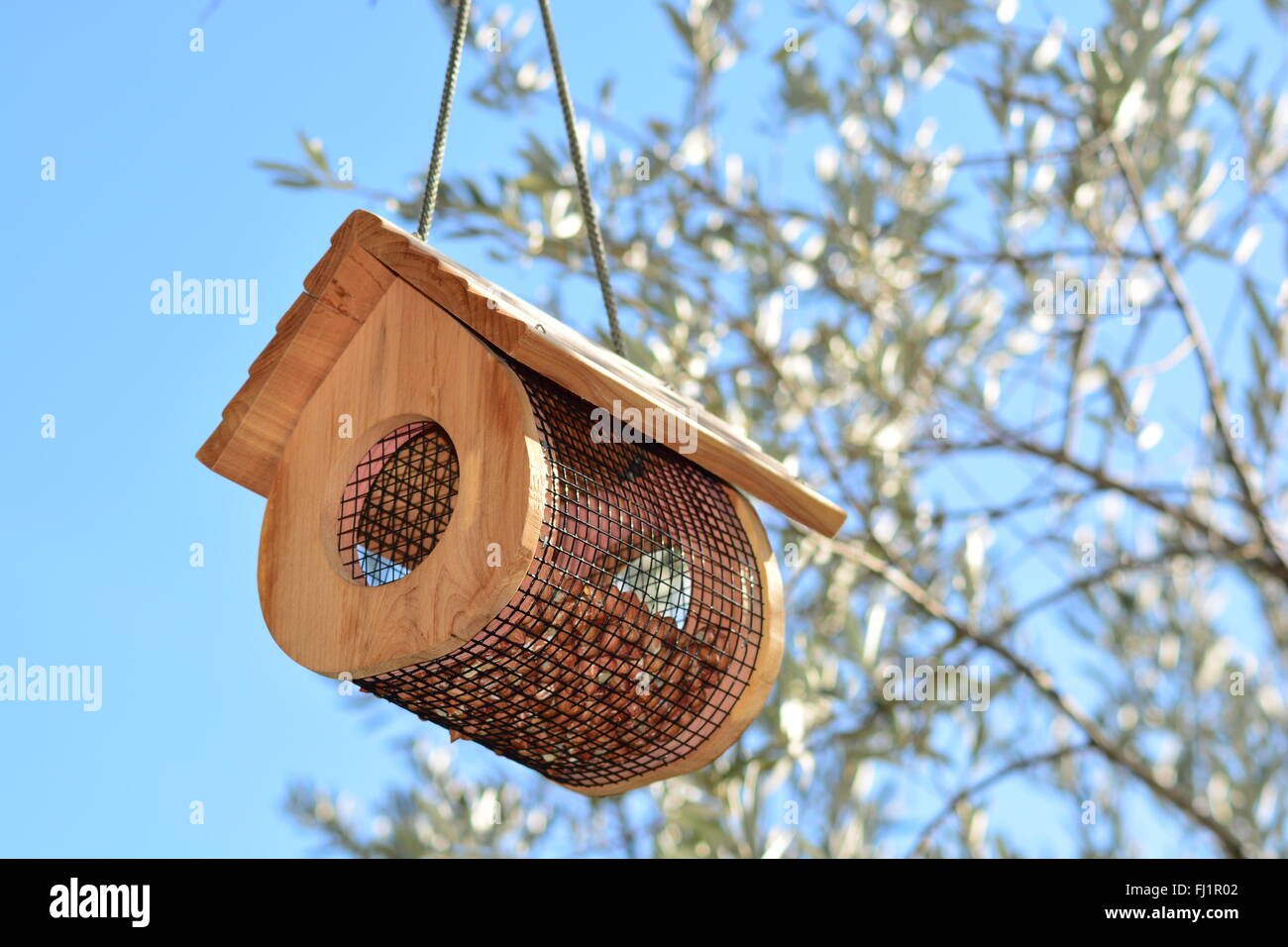 A Nice Bird Feeder In Shape Of A Cabin On A Blue Sky Day In Stock