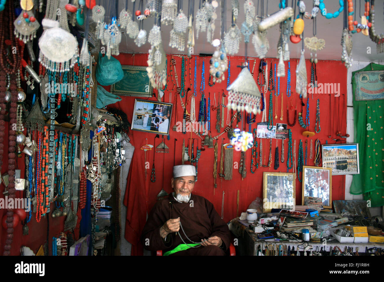 Old man selling jewels and handicraft in his shop in the old city of Leh , Ladakh , India Stock Photo