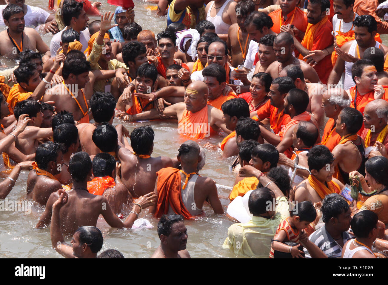 A guru is having a dip in the holy water of the Ganges at Har ki Pauri  in Haridwar during Kumbh mela Stock Photo