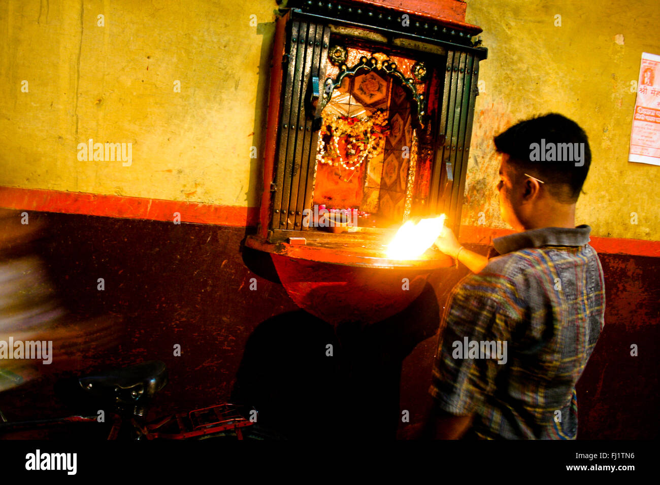 Hindu man praying in temple in a narrow street of Varanasi, India Stock Photo