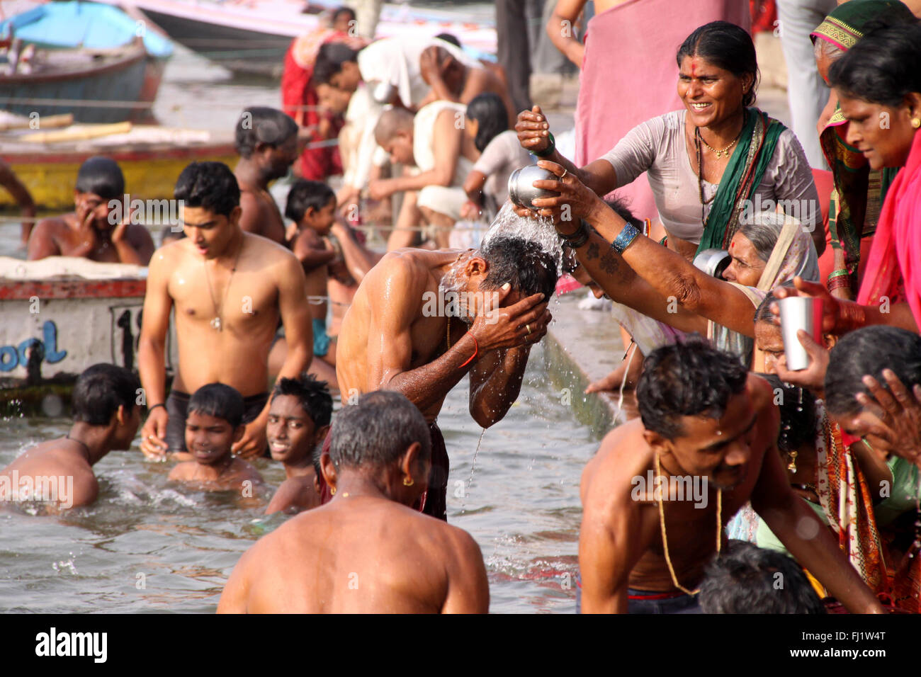 Hindu pilgrims taking a dip in holy Ganges water in Varanasi, India Stock Photo