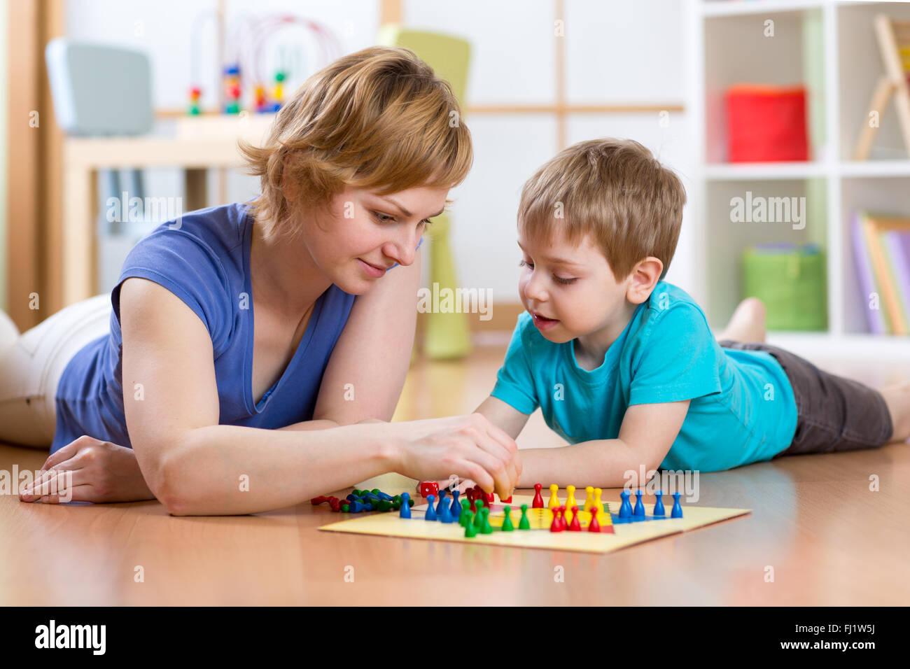 Family playing board game at home on the floor at home Stock Photo