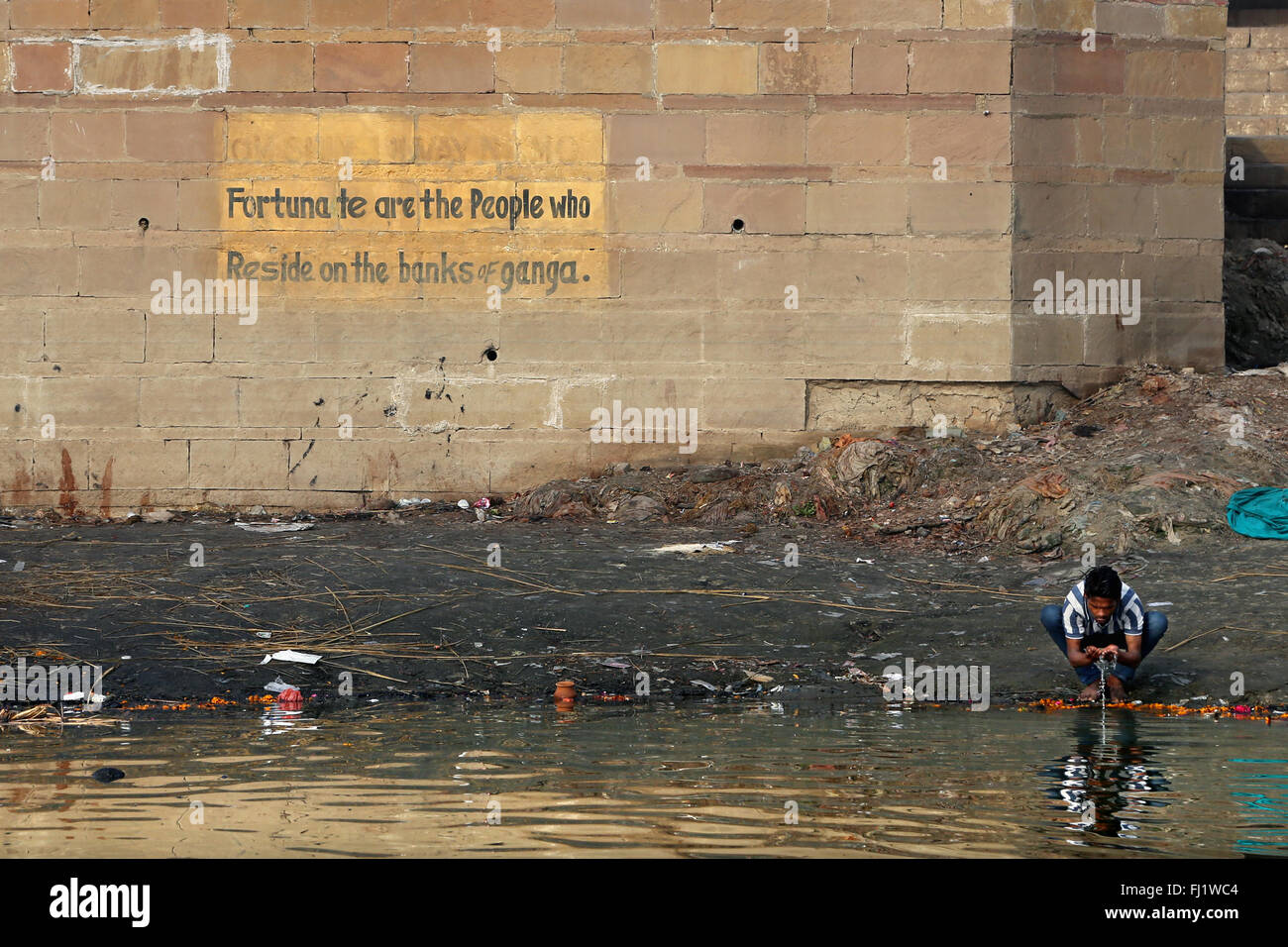 Man drinking holy water in polluted Ganges river in Varanasi , India Stock Photo