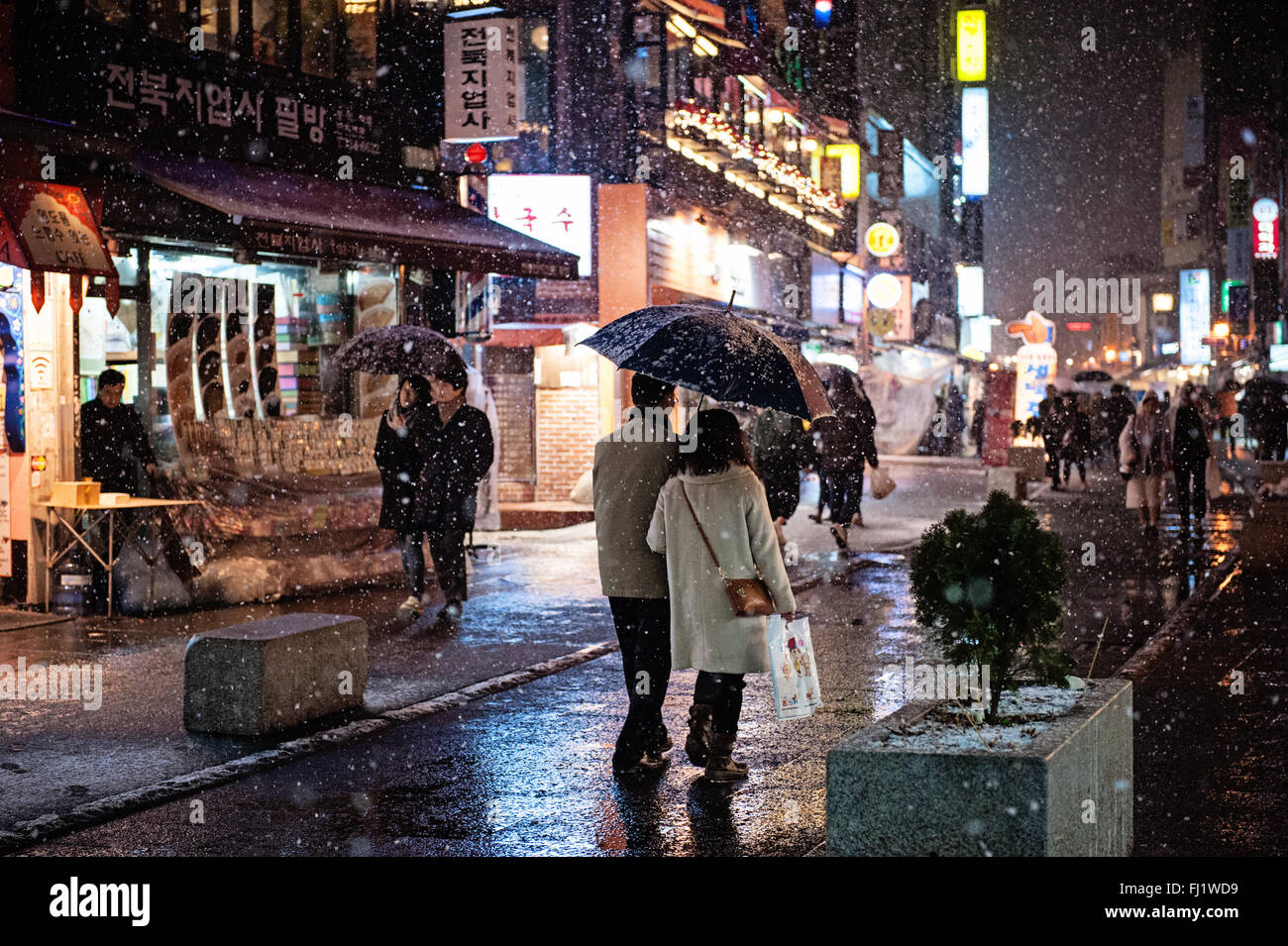Couples strolling through Insadong, Seoul, on a snowy evening. Stock Photo