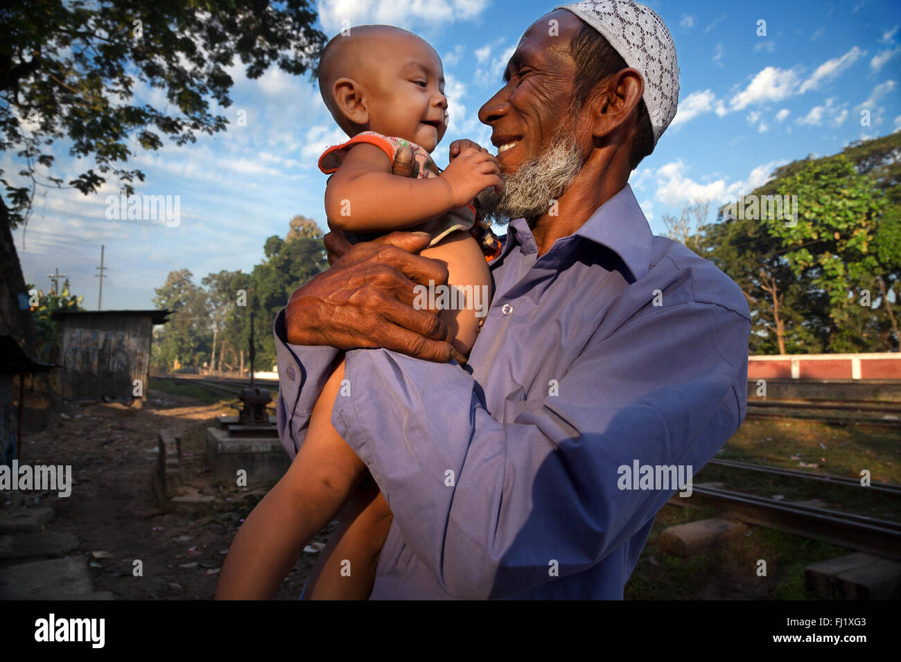 Happy smiling Muslim grandfather with child in Sreemangal Bangladesh Stock Photo