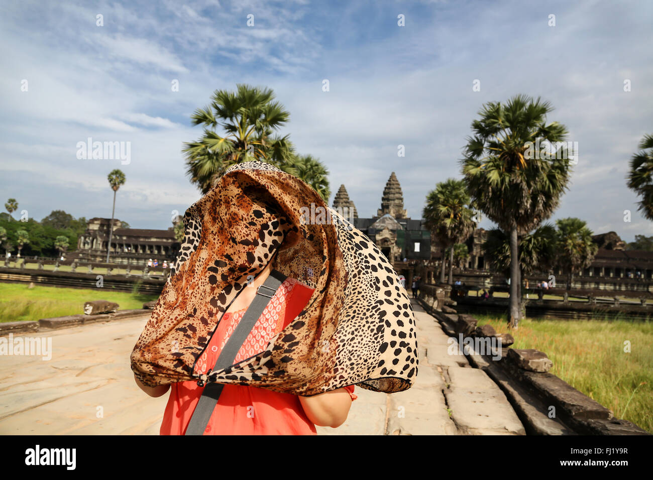 Tourist hidden under a jaguar pattern scarf in front of Angkor Vat, Cambodia Stock Photo