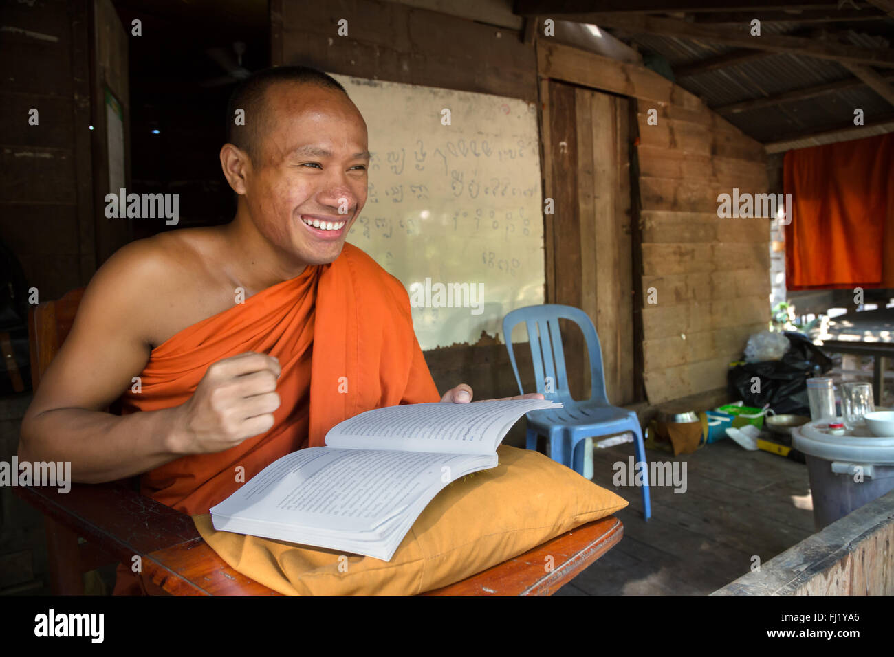 Buddhist monk reading book in monastery in Phnom Penh, Cambodia Stock Photo