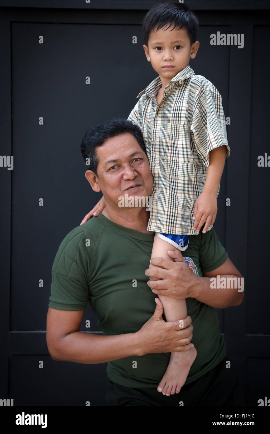 Cambodian man carrying kid in Phnom Penh Stock Photo