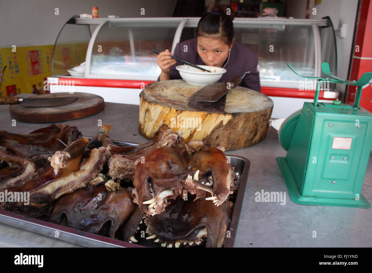 Woman eating dog meat in Guiyang,  China Stock Photo