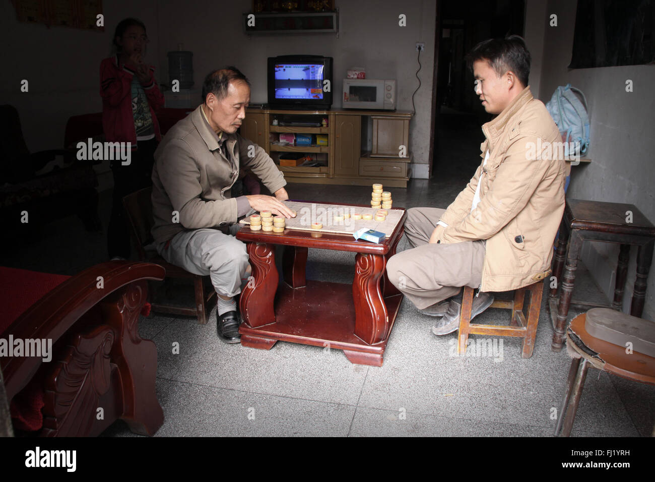 Two men play chess at home in Zhenyuan, Guizhou, China Stock Photo