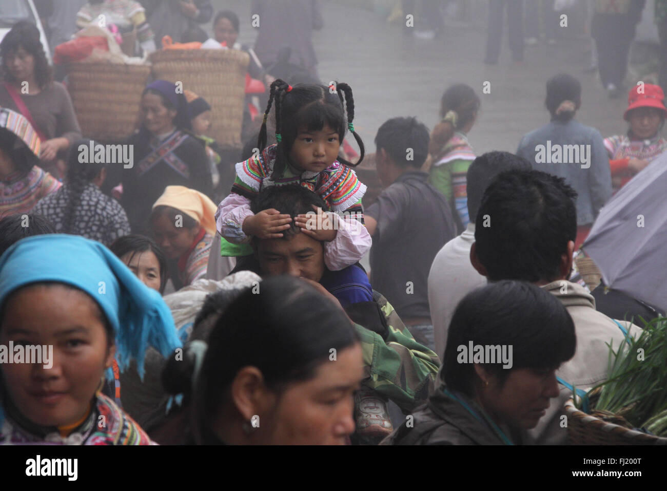 Tribal girl in the crowd at Yuanyang market, Yunnan Province ,  China Stock Photo