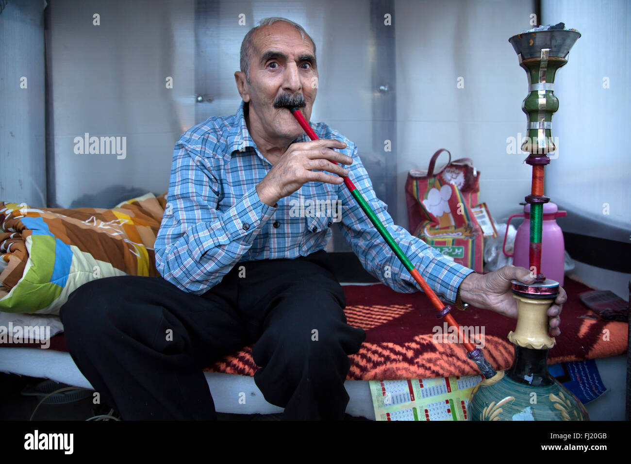 Portrait of old Iranian man smoking narghile waterpipe, Iran Stock Photo