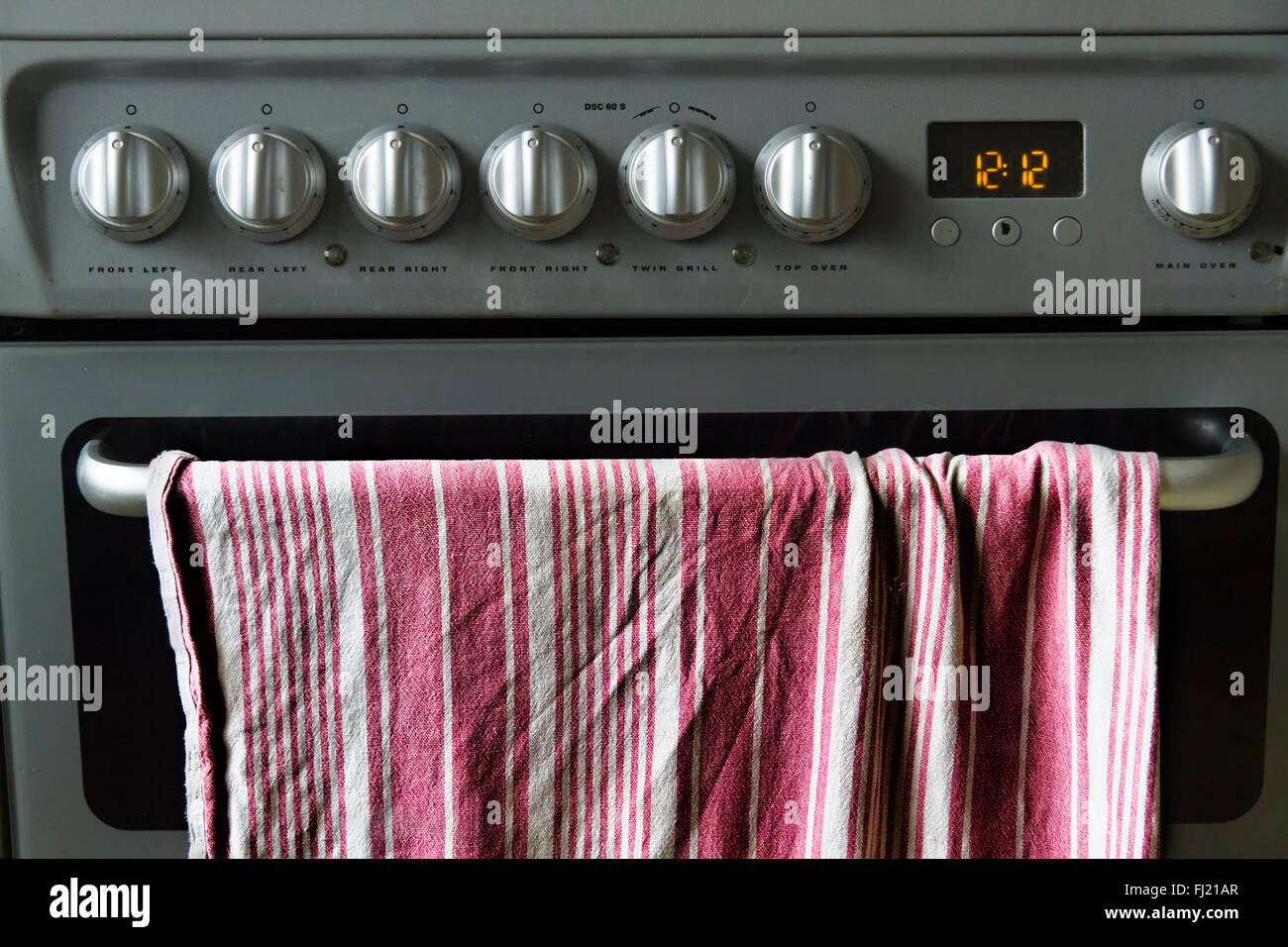 Tea towel or drying cloth hanging on an oven door handle of a