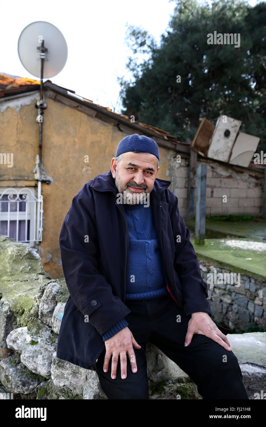 A man sits in front of a house in Fatih area , Istanbul Stock Photo