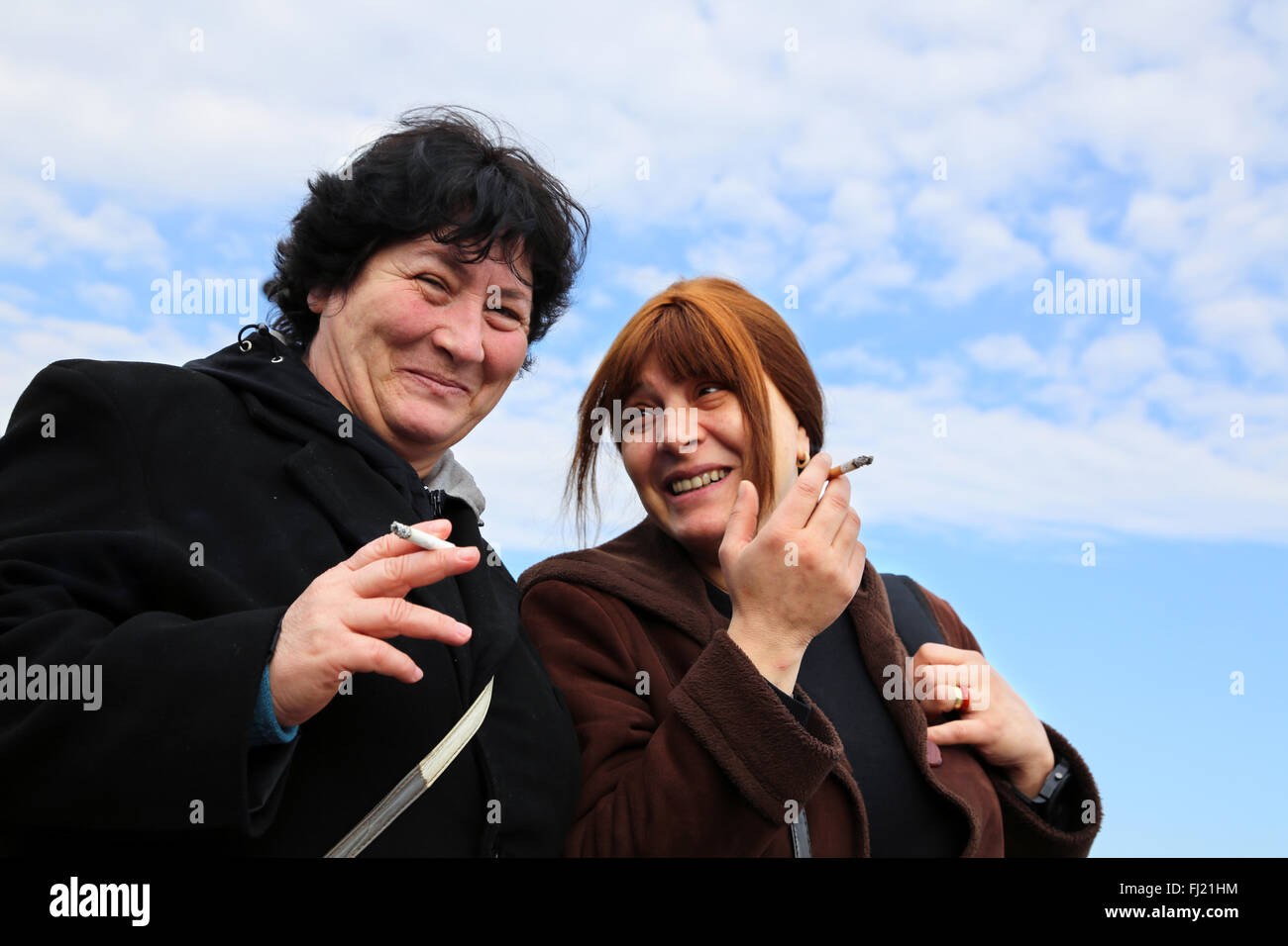 Two happy smiling Turkish women are smoking in the street in Istanbul Stock Photo