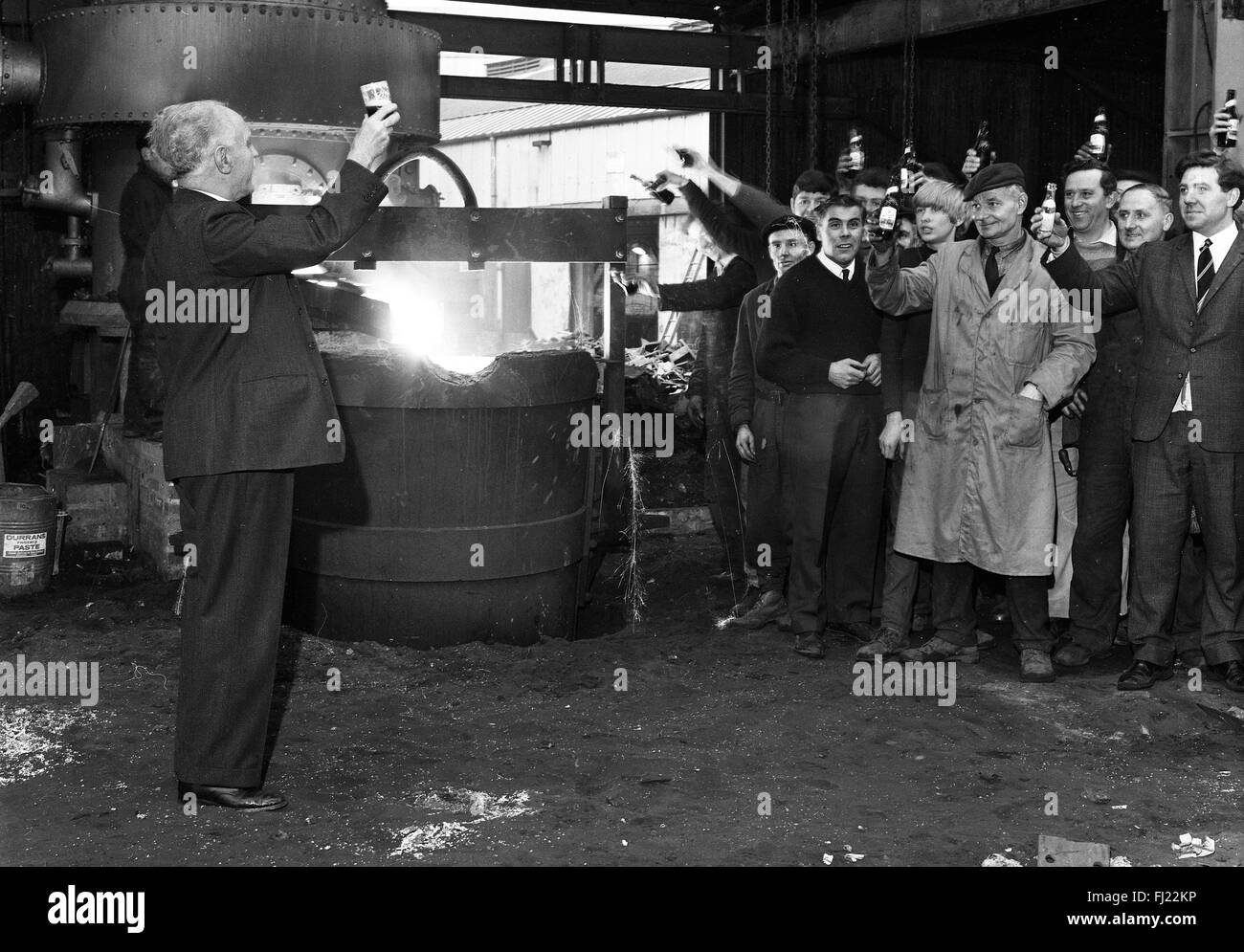 Steel iron workers celebrate lighting new furnace steel iron production factory Britain 1960s Stock Photo