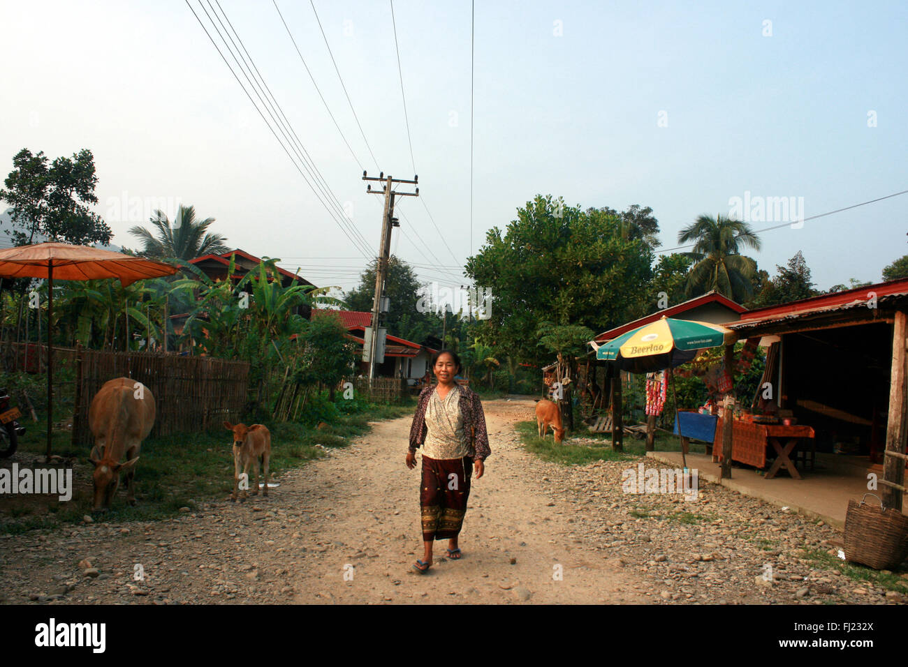 Asian laotian woman walking in the streets of Vang Vieng local people village (not touristic area ) Stock Photo