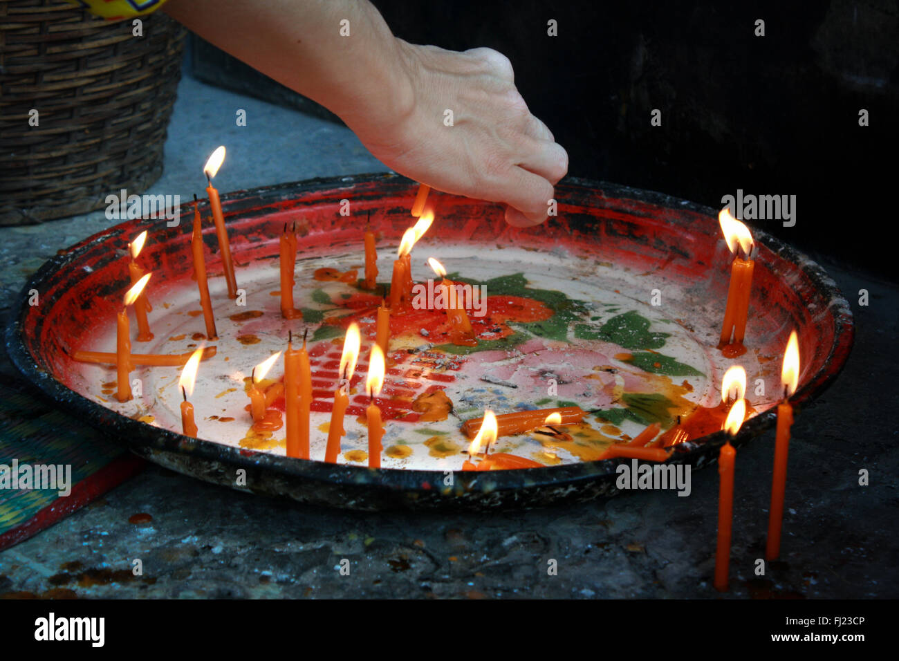 Woman lighting candles in a temple in Vientiane, Laos Stock Photo