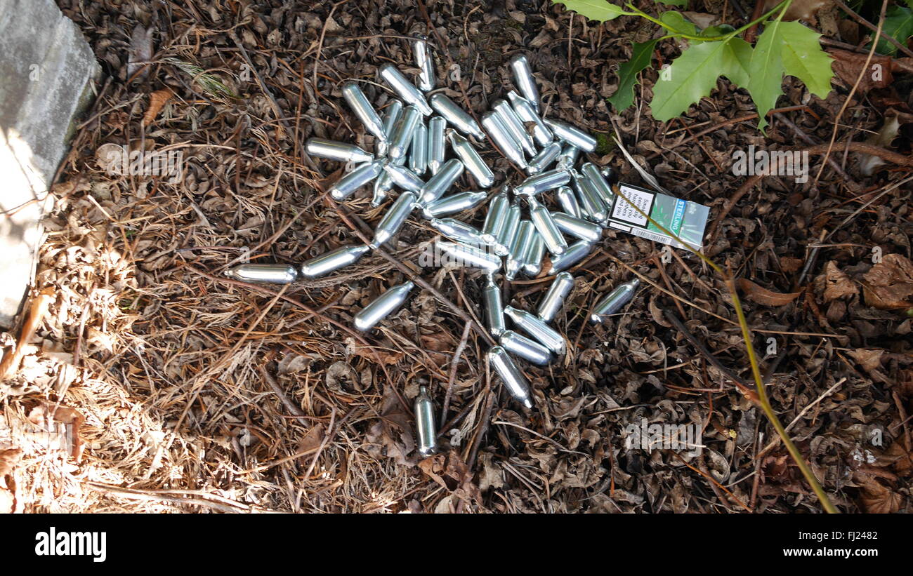 Dumped pile of empty silver canisters of nitrous oxide, or laughing gas, used as legal high picutred in London Stock Photo
