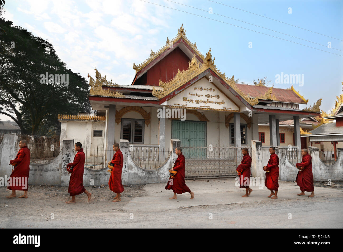 Buddhist monks receive rice from population, daily ritual, Nyaung-U, Myanmar Stock Photo