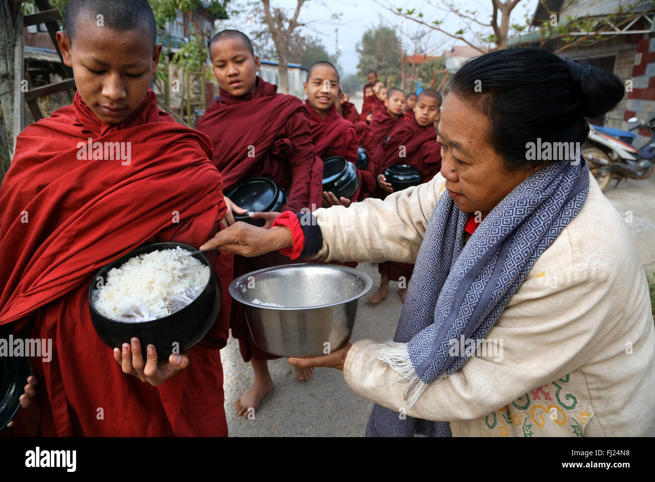 Buddhist monks receive rice from population, daily ritual, Nyaung-U, Myanmar Stock Photo