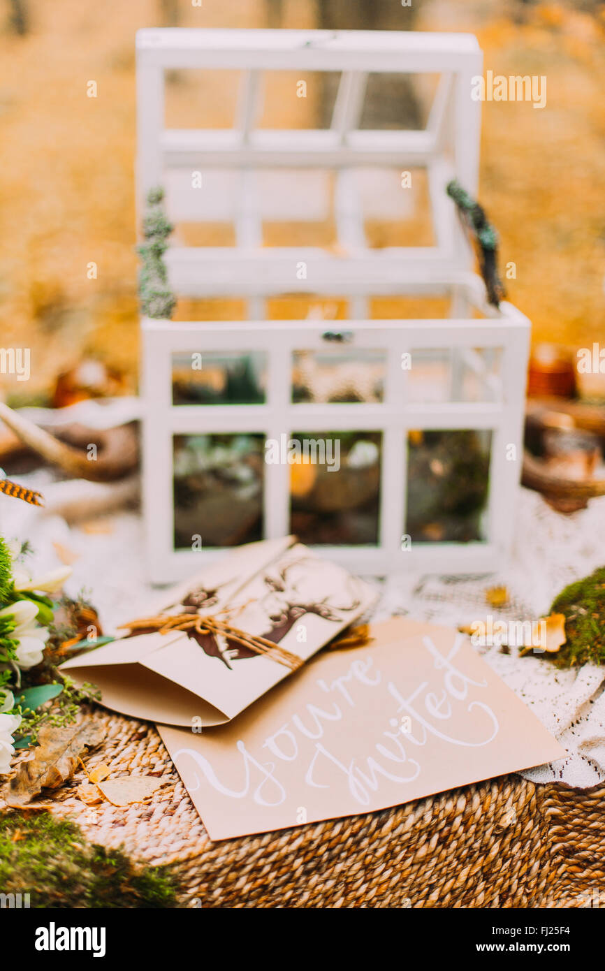 Wedding postcard invitation on the table decorated with wedding stuff. Autumn woods background Stock Photo