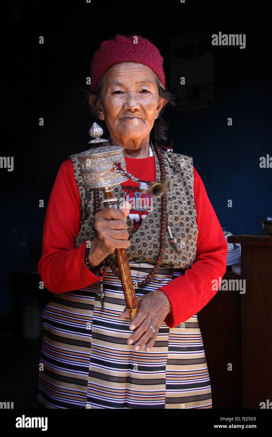 Portrait of buddhist Nepali woman with prayer wheel Stock Photo