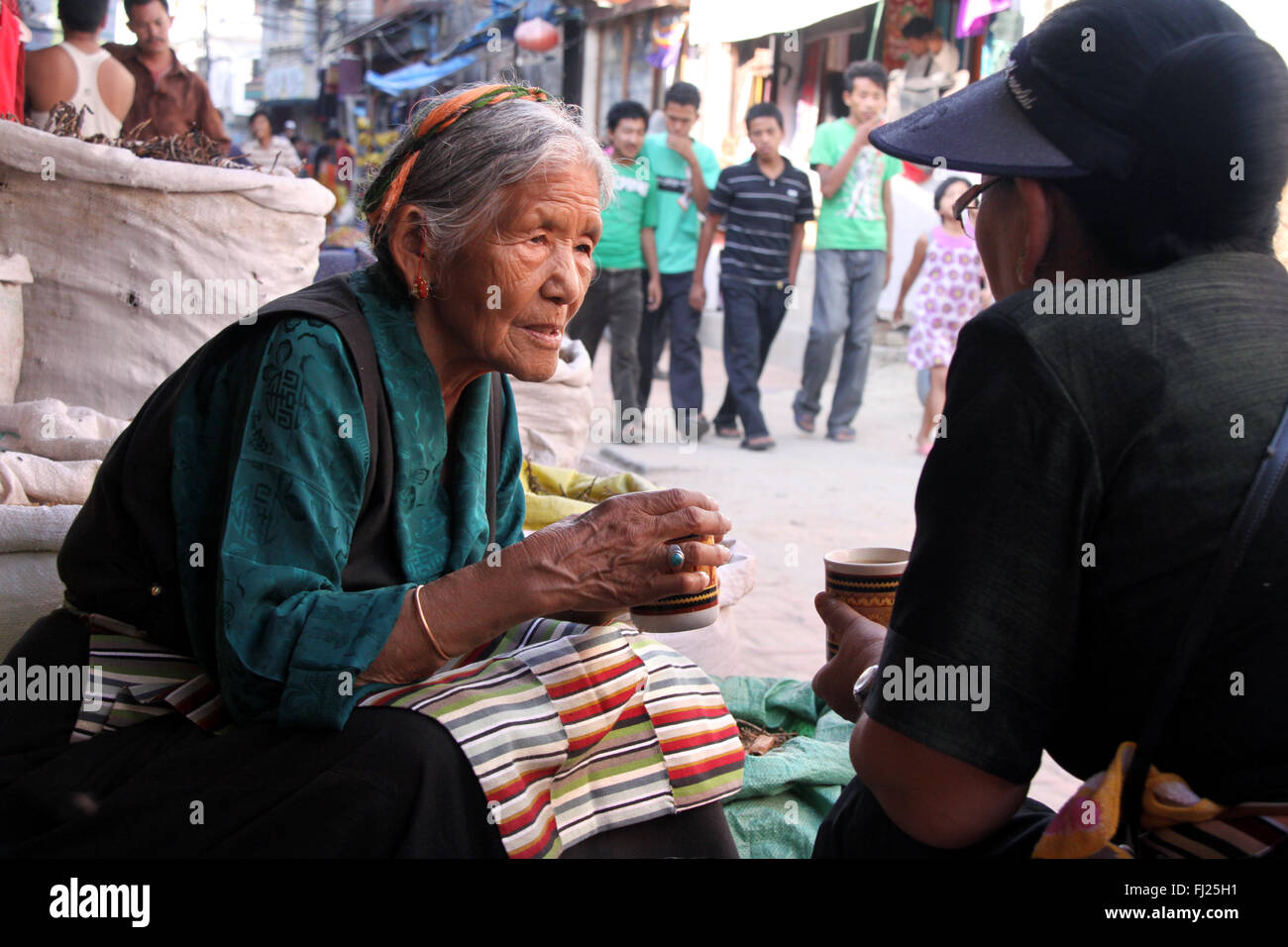 Two Newar women are talking and drinking tea in Boudhanath, Nepal Stock Photo