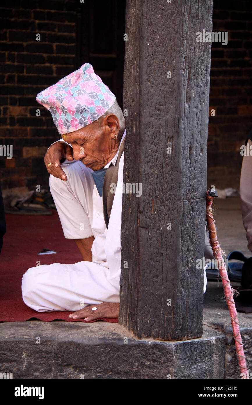 Nepalese Newar man with traditional costume and hat  'Dhaka topi' , in a temple in Patan, Nepal Stock Photo