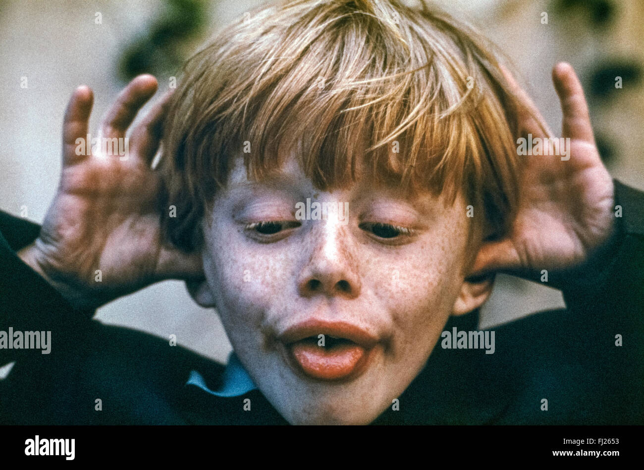 A young redheaded and freckled Swedish boy makes a funny face for the camera. Stock Photo