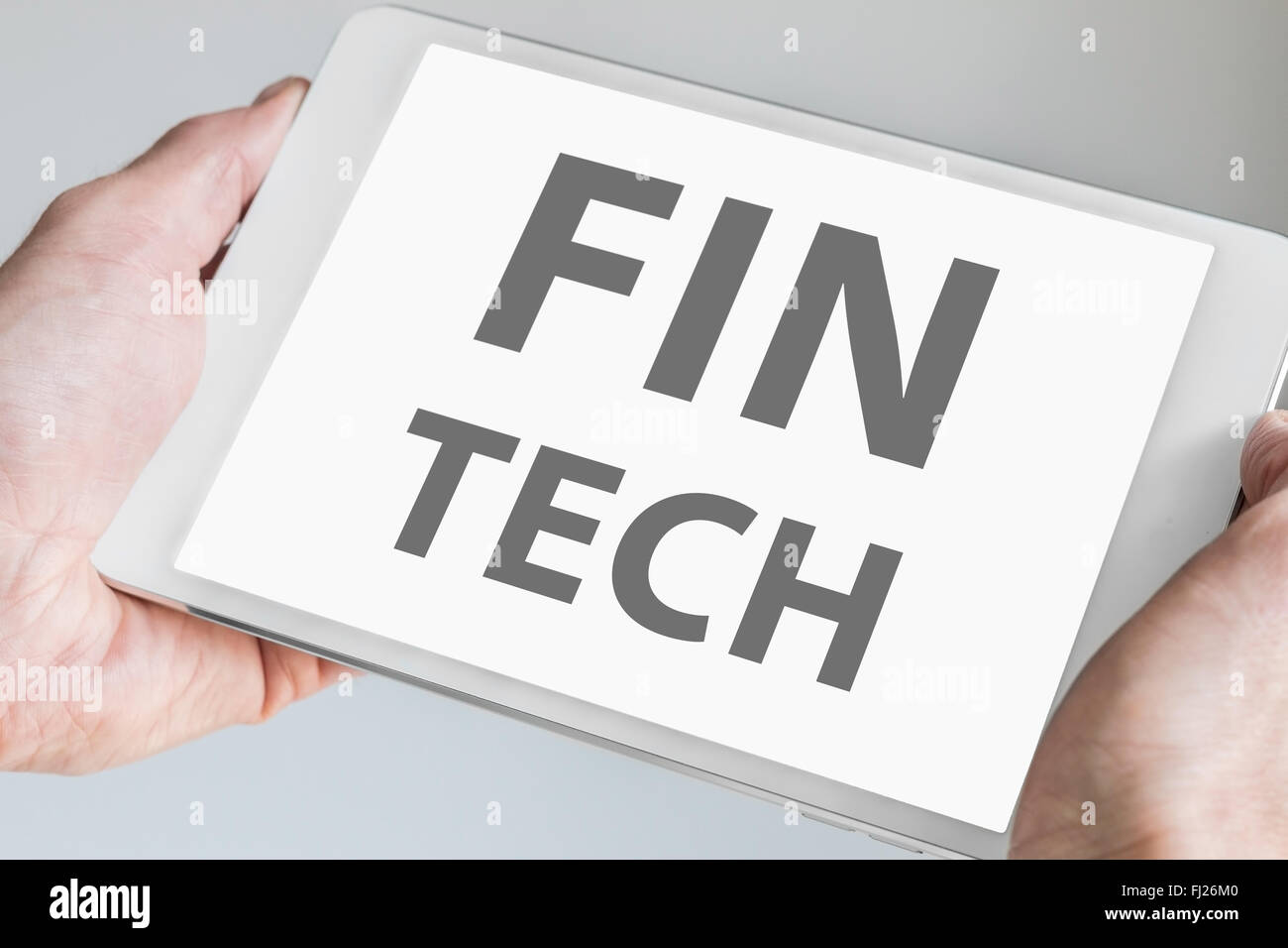 Fin tech text displayed on touchscreen of modern tablet or smart device. Concept of financial technology startup company. Stock Photo