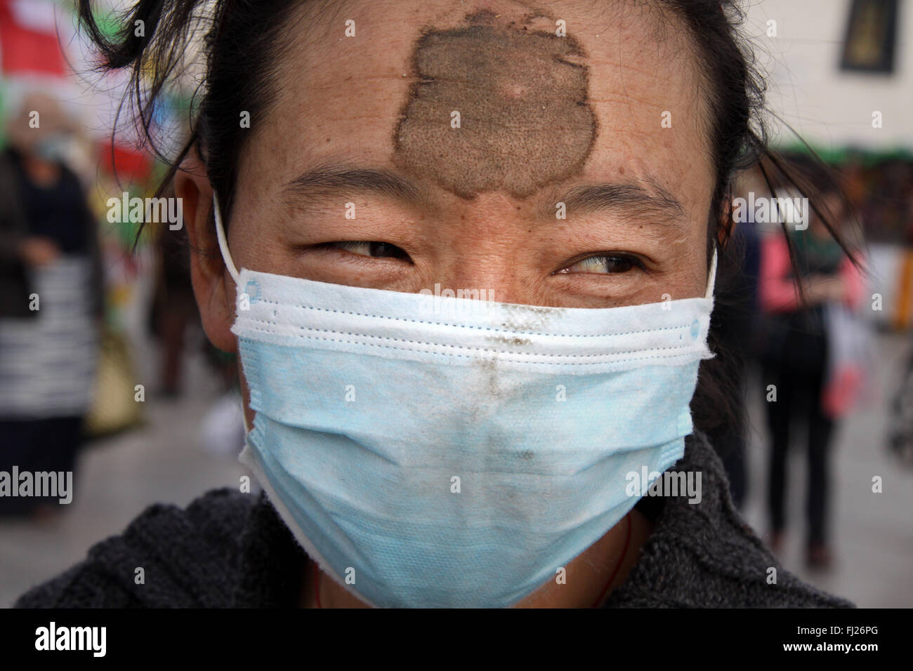 Tibetan woman praying with mud on her forehead as she prays on the floor in Lhasa , Tibet Stock Photo