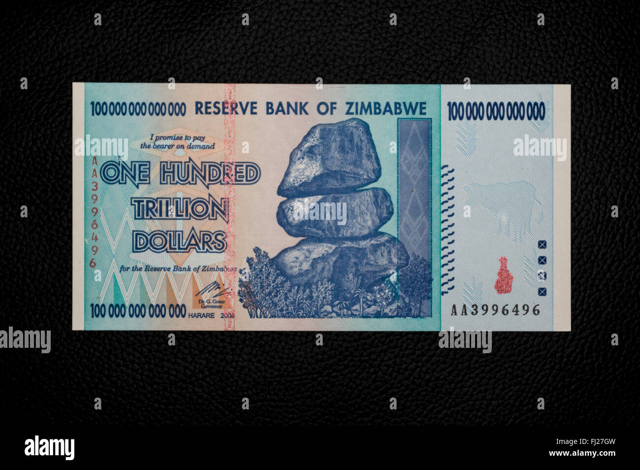 One hundred trillion dollars banknote issued in Zimbabwe in 2008, on the climax of the hyperinflation. Black background. Stock Photo