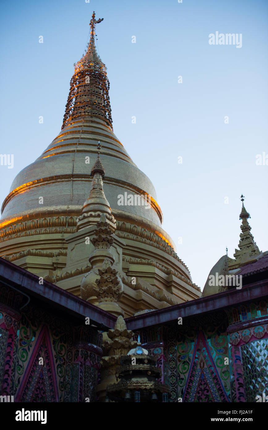 Sutaungpyei Pagoda Golden Stupa Mandalay Myanmar // MANDALAY, Myanmar — Sutaungpyei Pagoda (also known as Su Taung Pyae Pagoda) crowns the summit of Mandalay Hill, its golden stupa rising above ornate pavilions and shrines. The pagoda was constructed during the reign of King Mindon in the mid-19th century as part of his establishment of Mandalay as the new royal capital in 1857. The name translates to 'wish-fulfilling,' reflecting its spiritual significance as a place where Buddhist devotees come to make merit and seek blessings. The complex features impressive mirrored mosaic walls and houses Stock Photo