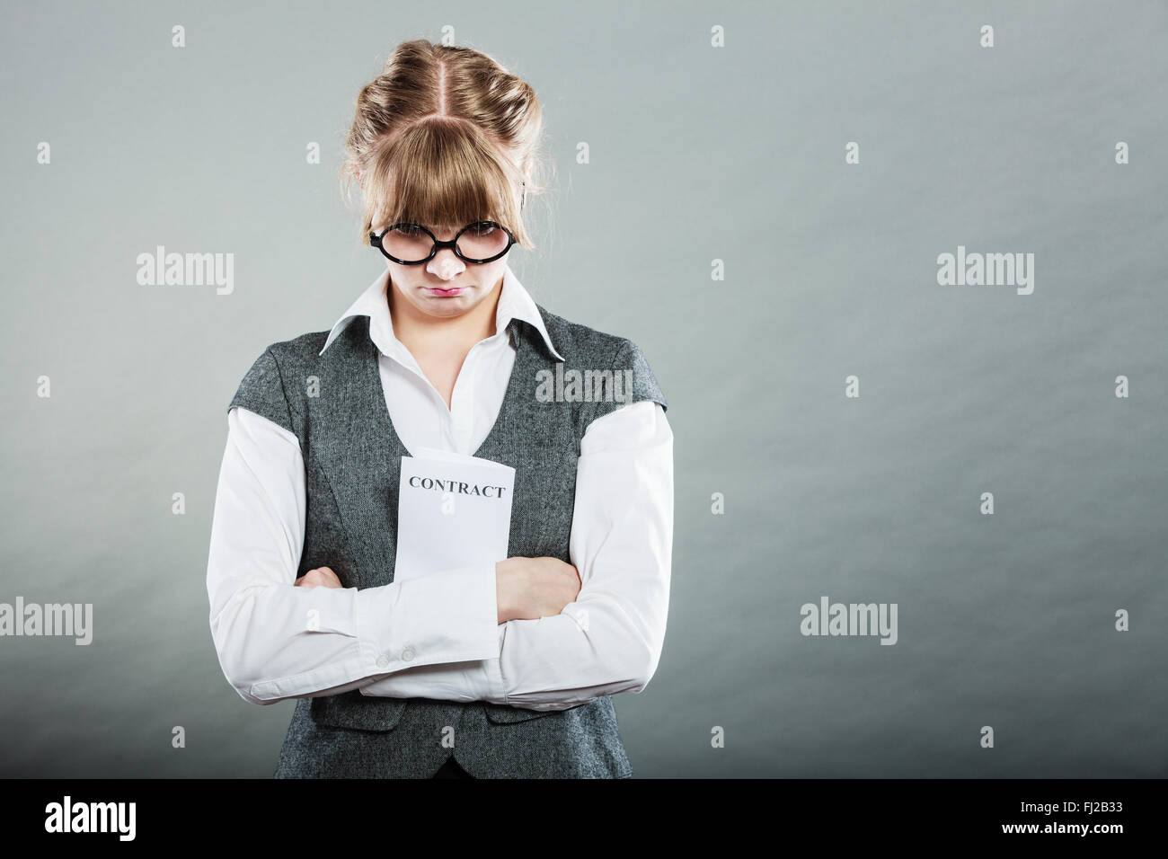 Business documents legal concept - closeup skeptical unhappy businesswoman holding contract in hands. Negative human emotion. Stock Photo