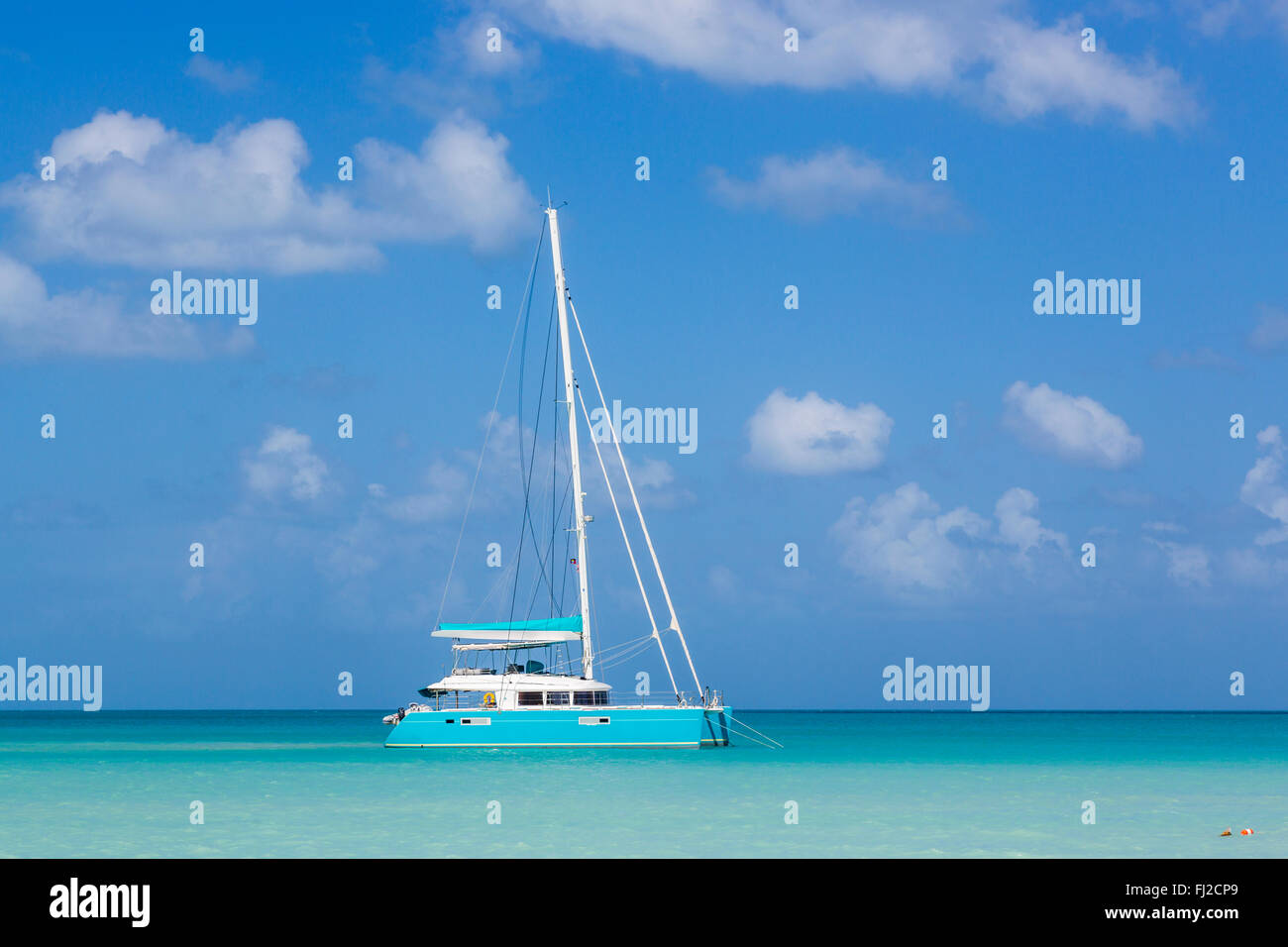 Blue catamaran anchored in Dickenson Bay, north Antigua, Antigua and Barbuda, West Indies with blue sky and turquoise sea Stock Photo