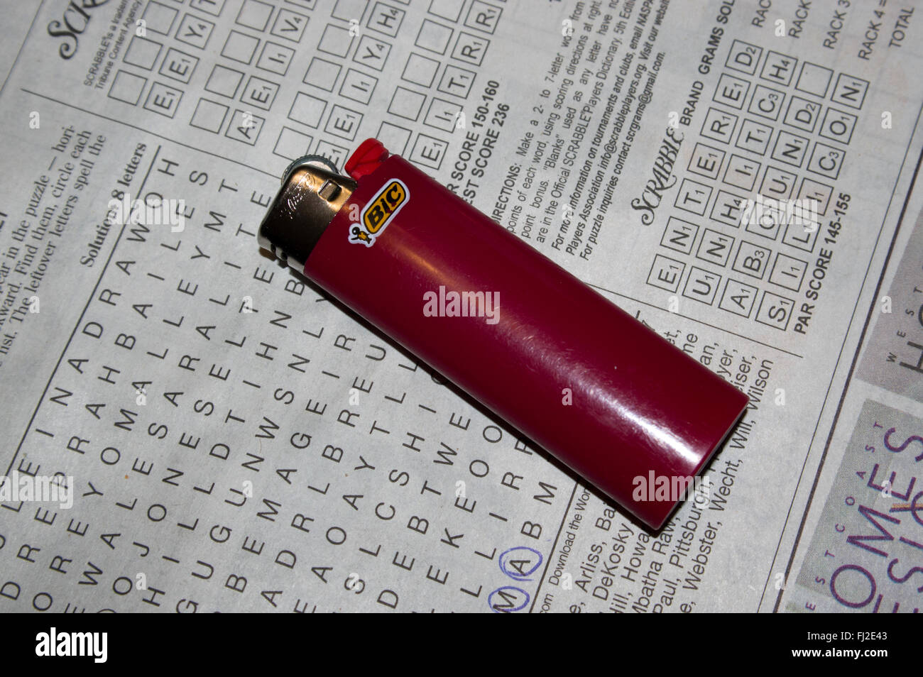 news paper, crossword, red lighter, red bic lighter Stock Photo