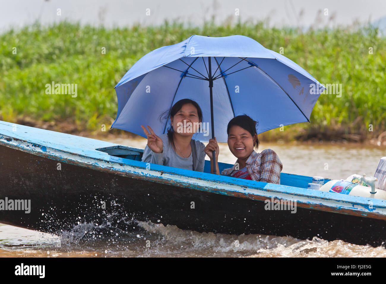 BURMESE woman use an umbrella as sun protection on INLE LAKE - MYANMAR Stock Photo