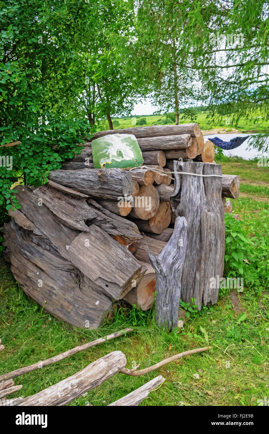 Village landscape. Firewood stacked in a pile sailed on the water of the river. Stock Photo