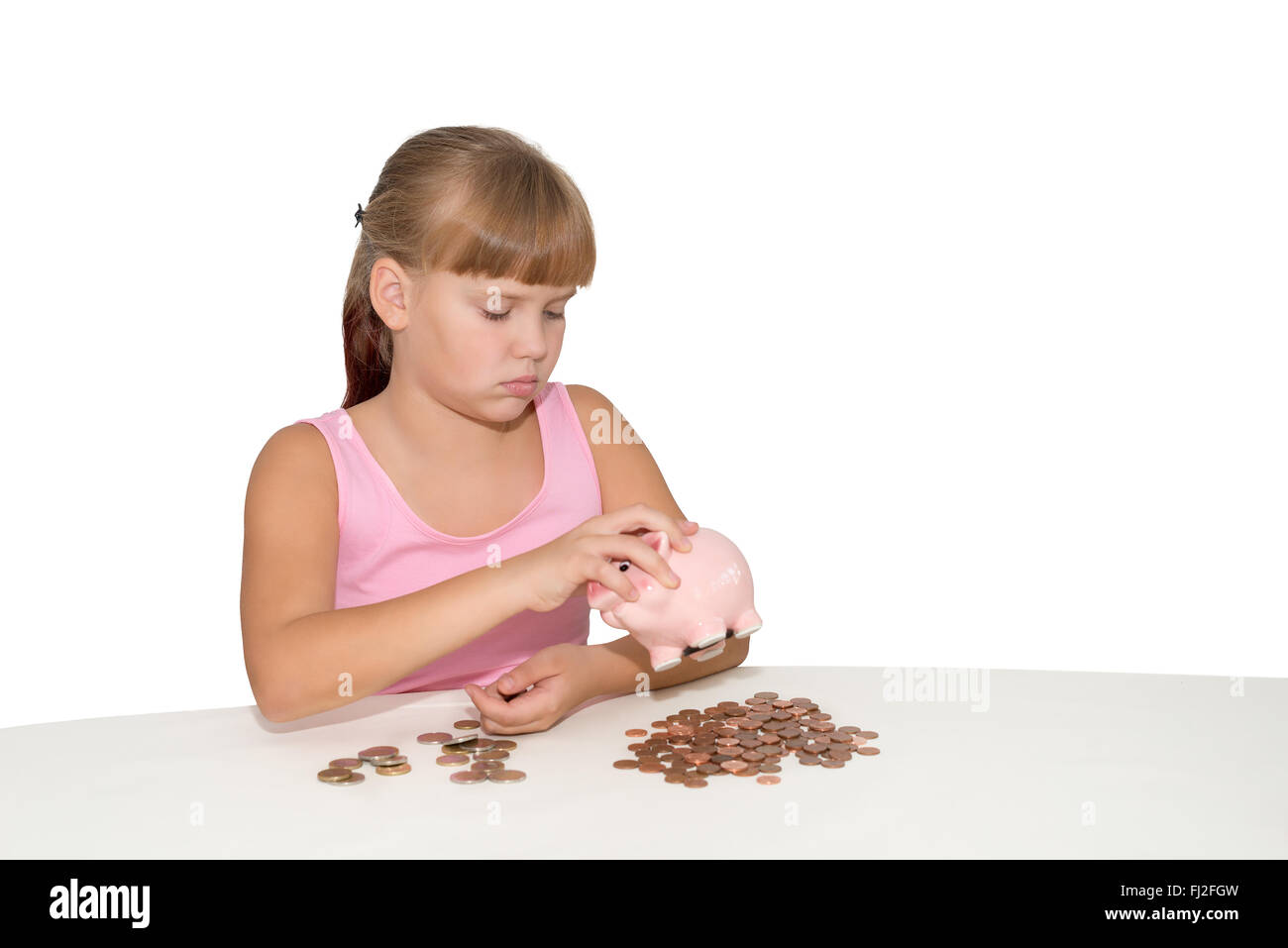 Sad girl looking at the piggy bank with coins on table isolated Stock ...