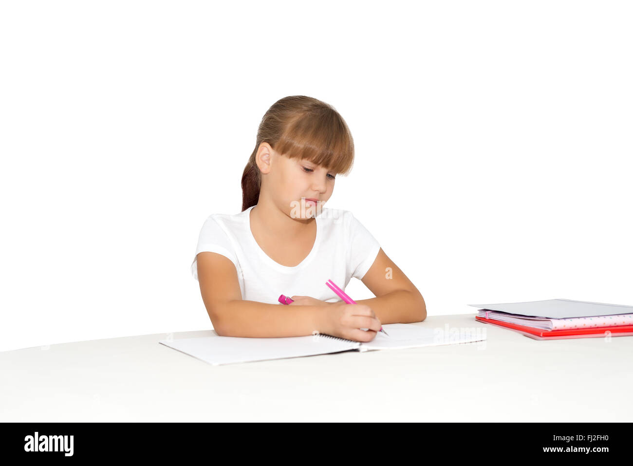 Little girl doing homework at the desk isolated Stock Photo
