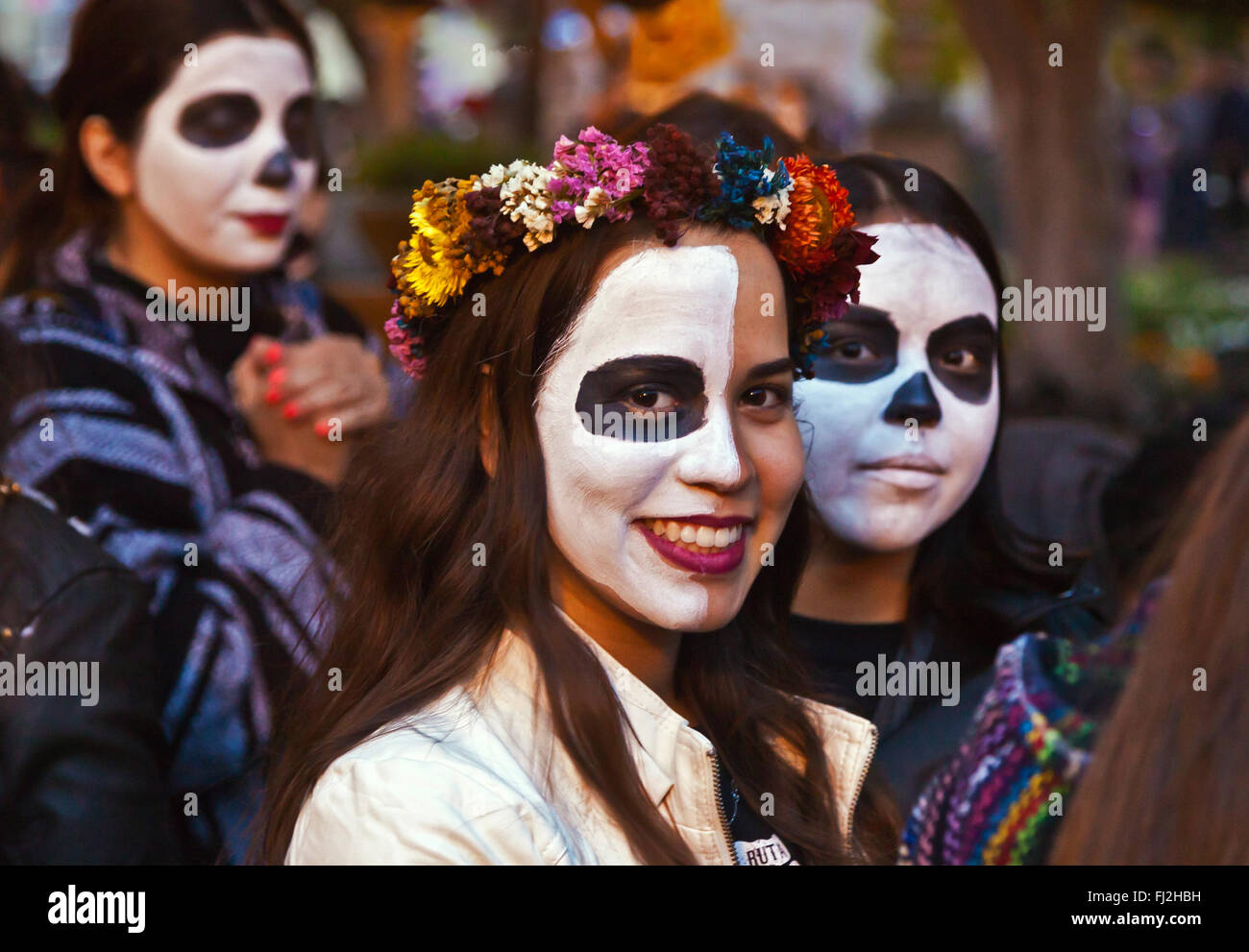 Faces are painted like skulls as people transform themselves into CATRINAS during DAY OF THE DEAD  -  SAN MIGUEL DE ALLENDE, MEX Stock Photo