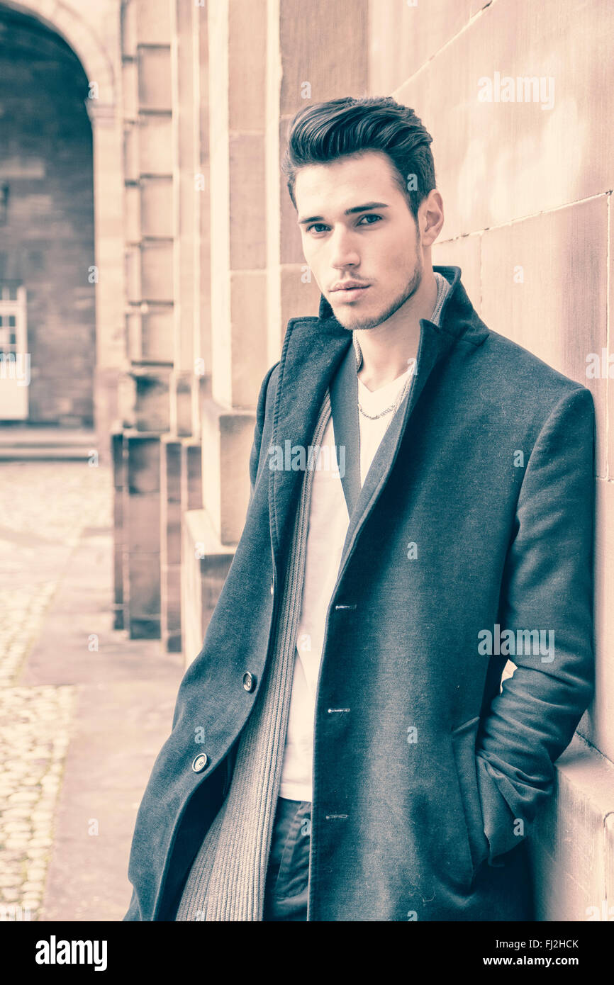 Handsome young man outdoor in winter fashion, wearing black coat and ...