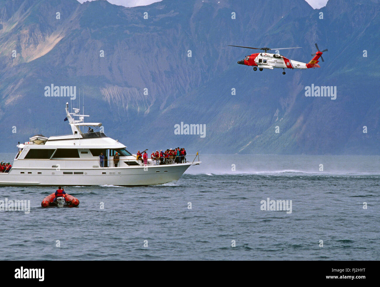 RESCUED PASSENGERS from the YORKTOWN CLIPPER aboard a private vessel with COAST GAURD HELICOPTER assisting - GLACIER BAY, ALASKA Stock Photo