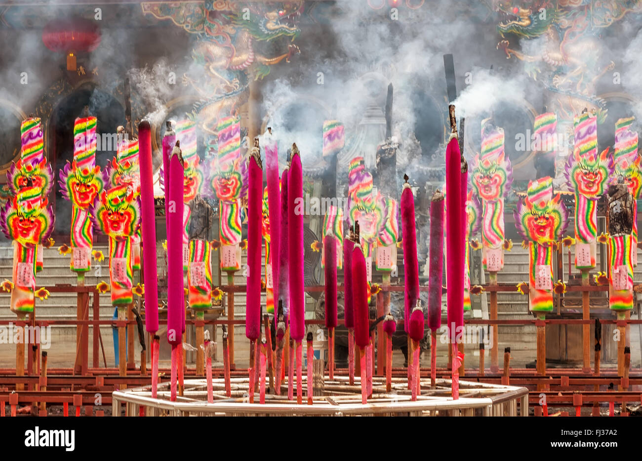 Chinese magenta and multicolored colored  incenses with smoke Stock Photo