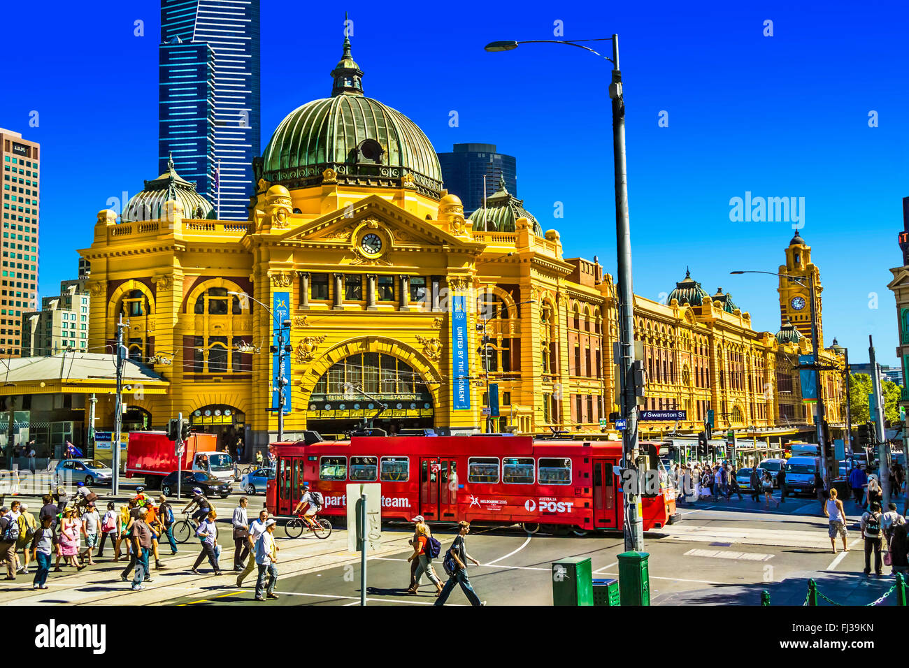 People crossing Flinders Street the Swanston St intersection red Melbourne tram at Flinders Street Station Australia Stock Photo