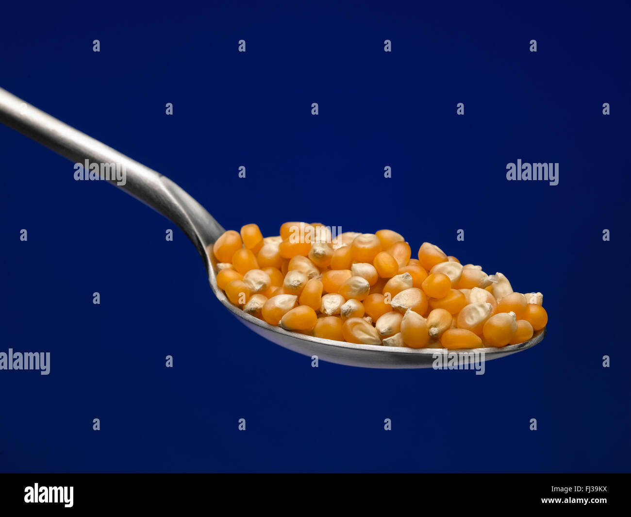 Popping corn on spoon Stock Photo