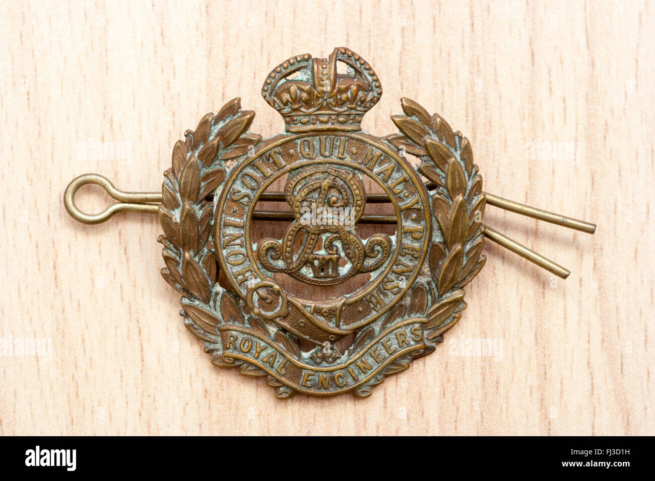 First world war, the great war. Regalia. rmy cap badge of the Royal Engineers against wood grain background. Stock Photo