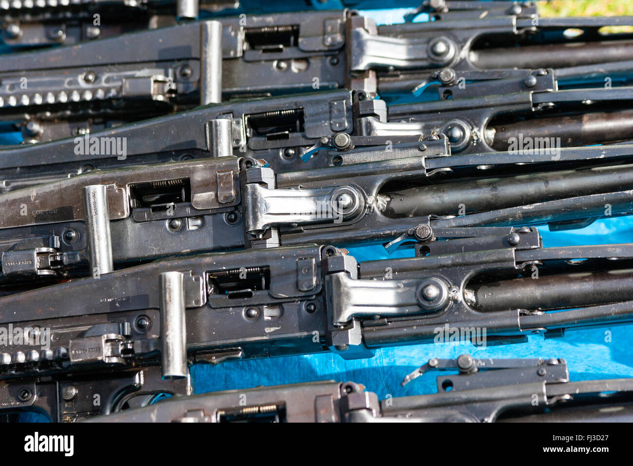War and peace show market place area. Row of five German second world war MG42 machine guns for sale on blue mat. Close up. Stock Photo