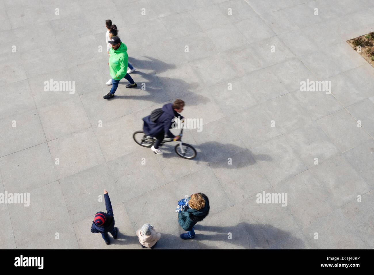 People and cycler on square, pedestrians, walking viewed from above, high view. Stock Photo